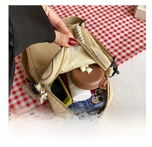Detail view of the khaki canvas crossbody bag showing its spacious internal capacity