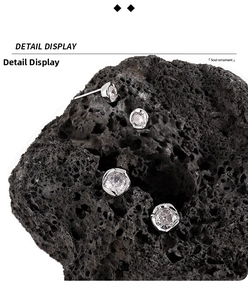 Detailed close-up of minimalist S925 sterling silver stud earrings with sparkling white zircons