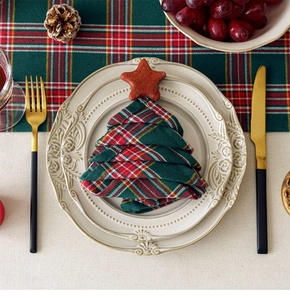 Christmas table setting with red plaid napkin tree, gold cutlery and festive plates