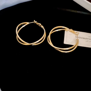 Detailansicht goldener Doppelreifen-Ohrringe mit überkreuztem geometrischem Design