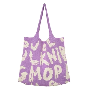 Detail of purple and white knitted tote bag texture and woven letter jacquard pattern