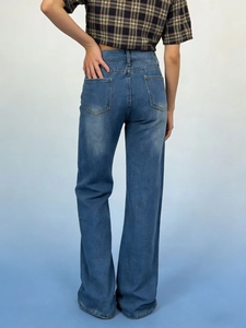 Vista posteriore di jeans larghi blu da donna che mostrano trama del tessuto e taglio