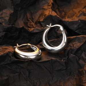 Polished silver geometric U-shaped hoop earrings on elegant black textured backdrop