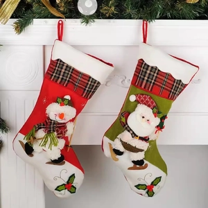 Chaussettes de Noël avec bonhomme de neige et Père Noël en peluche sur une cheminée festive