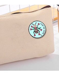 Detailed close-up of a cartoon ant metal pin with I was An Ant text on a canvas bag