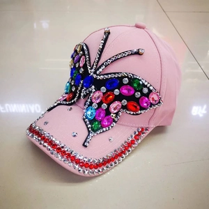 Pink baseball cap featuring a large crystal butterfly and rhinestone-studded brim detail