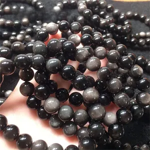 Macro shot of 6A grade obsidian beads showing natural silver sheen and smooth texture
