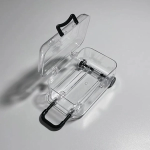 Detailed view of an open transparent mini suitcase jewelry box with black wheels and handle