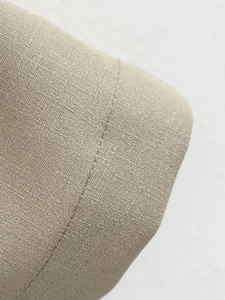Makro-Detail der khakifarbenen Baumwoll-Leinen-Textur und sauberen Nähten des Blazer-Sets