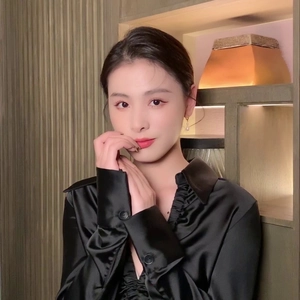 Close-up of black satin shirt detailing the pleated collar and elegant button-down design