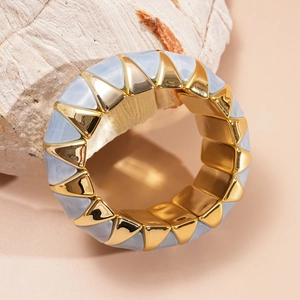 Detailed shot of wide stretch bracelet with blue marble acrylic and gold metal triangles