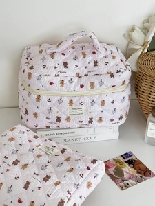 Détail de la trousse cosmétique matelassée rose avec motifs d'ours et étiquette rétro
