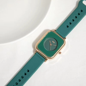 Detailed view of women's vintage square quartz watch with green strap and gold bezel