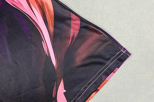 Detail of colorful abstract print fabric with smooth texture and fine overlock stitching