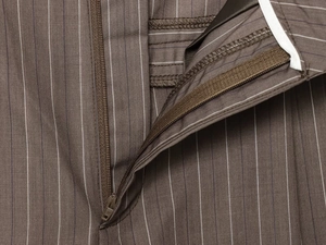 Détails de la fermeture éclair et du tissu à fines rayures sur le pantalon marron foncé