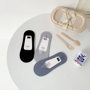 Three pairs of seamless ice silk no-show socks in black, grey, and blue on a white table