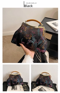 Detail of black satin embroidery handbag with wooden handle, floral patterns and silk tassel