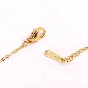 Detail shot of golden stainless steel necklace clasp and S.STEEL engraved metal tag