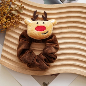 Detailed view of a brown velvet Christmas reindeer scrunchie on a wooden stand