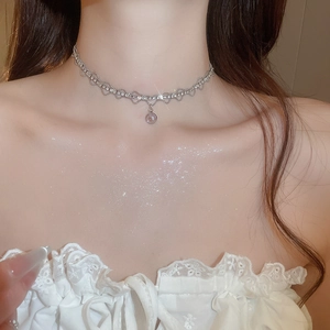 Detailed view of sparkly rhinestone lace choker with round pendant on model neck