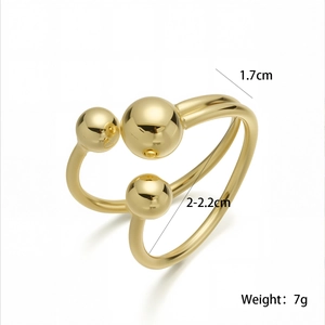 Detailed view of gold multi-layer geometric open ring with polished metal spheres