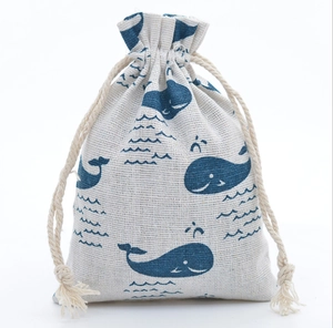 Detailed view of linen drawstring bag featuring blue whale and ocean wave prints
