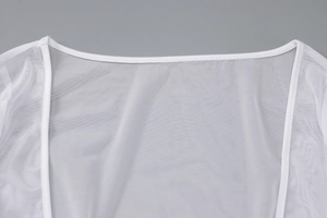 Détails du tissu en maille blanche transparente et coutures précises sur la robe d'été