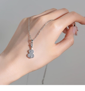 Detail of silver violin pendant necklace with shimmering cubic zirconia micro-pave setting