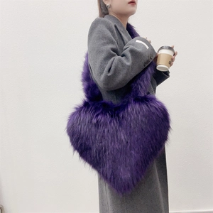 Detail of a large purple faux fur heart-shaped shell bag with fluffy winter texture