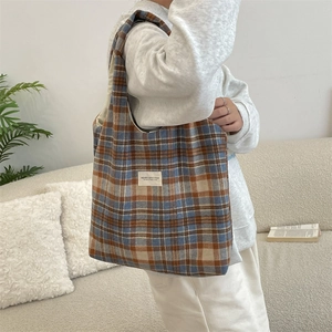 Close-up of retro plaid wool tote bag showing thick texture and minimalist woven label