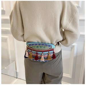 Close-up of ethnic lace waist bag with colorful tassels and wave pattern embroidery