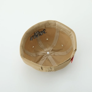 Detail view of the cotton canvas inner structure and reinforced seams of a beige skull cap