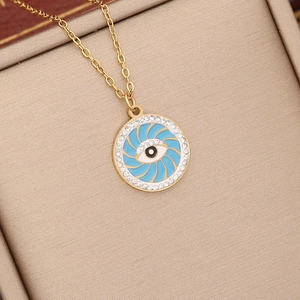 Close-up of golden evil eye necklace with blue swirl center and rhinestone bezel