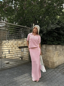 Detail of pink crochet knit polo top and matching openwork skirt with hollow texture