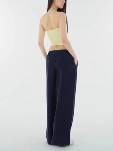 Rear view of loose-fit wide-leg navy trousers showing smooth fabric drape and waist detail