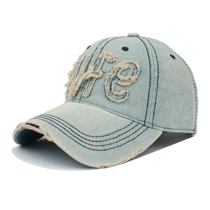 Détail de la broderie LIFE sur une casquette de baseball en jean bleu délavé usé