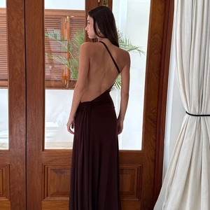 Gros plan sur le dos nu et le tissu marron soyeux de cette robe élégante à une épaule