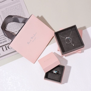 Pink jewelry gift box set with paper bag and necklace featuring blue stone accents