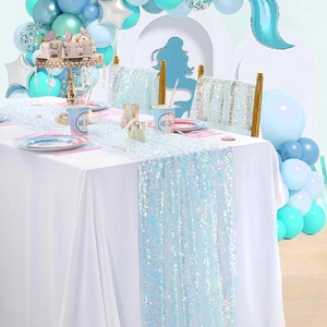 Dettaglio del runner da tavola con paillettes blu per una festa a tema sirena.