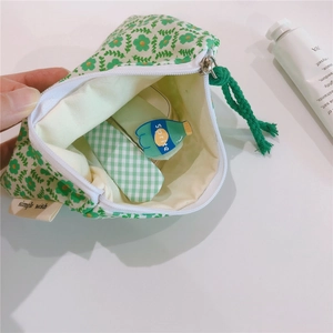 Detail of floral cotton mini pouch showing light beige lining and interior storage capacity