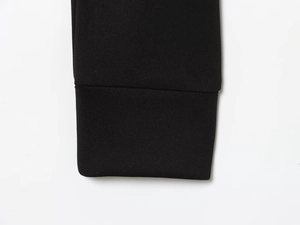 Close-up of black knit sleeve cuffs showing detailed stitching and fabric texture