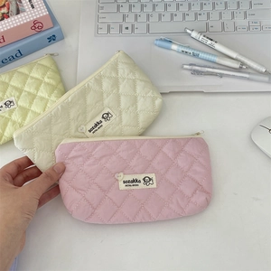 Quilted diamond pattern pencil case in pink and beige colors with a cute brand label
