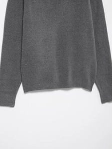 Detailed view of the ribbed hem and cuffs on a dark grey fine knit cashmere sweater