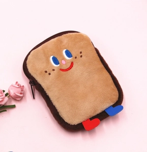 Gros plan du mignon porte-monnaie toast en peluche avec visage brodé sur fond rose
