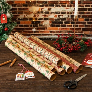Christmas kraft wrapping paper rolls with festive tree and reindeer prints on wooden desk
