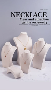 Set of four beige velvet bust necklace stands in varying heights on a marble surface