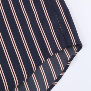Detailed close-up showing the precise stitching on the curved hem of this striped shirt