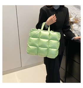 Dettaglio della borsa tote trapuntata verde chiaro in nylon imbottito con manici spessi