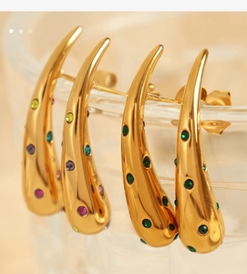 Macro shot of 18K gold plated teardrop earrings with colorful crystals on glass rim