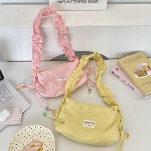 Dettaglio delle borse a nuvola in tela arricciata rosa e gialla con coulisse